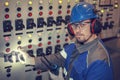 Electrician at work inspecting cabling connection of high voltage power electric line in industrial distribution fuseboard, toned Royalty Free Stock Photo