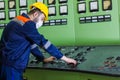 Electrician at work, man working in a factory on medical mask, engineer at work on yellow helmet and protective mask,