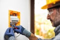 Electrician at work with safety equipment on a residential electrical system. Electricity Royalty Free Stock Photo