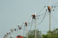 Electrician worker climbing electric power pole to repair the damaged power cable line problems after the storm. Power line Royalty Free Stock Photo