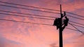 Electrician worker climbing electric power pole to repair the damaged power cable line problems after the storm. Power line Royalty Free Stock Photo