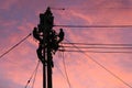 Electrician worker climbing electric power pole to repair the damaged power cable line problems after the storm. Power line Royalty Free Stock Photo