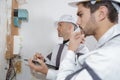 Electrician workers checking voltage fuse board