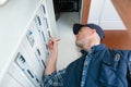 Electrician working with electric scheme plan in front fuse-switch-board Royalty Free Stock Photo