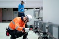 Electrician working on electrical system maintenance on rooftop, industrial worker is concentrated on wiring installation, Royalty Free Stock Photo