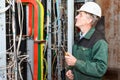 Electrician working in hard hat with cables Royalty Free Stock Photo