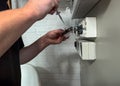 An electrician is working on installing a lighting dimmer