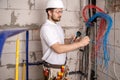 Electrician working near the Board with wires. Installation and connection of electrics