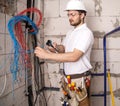 Electrician working near the Board with wires. Installation and connection of electrics