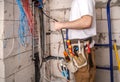 Electrician working near the Board with wires. Installation and connection of electrics