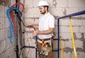 Electrician working near the Board with wires. Installation and connection of electrics