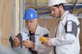 Electricians checking socket voltage with digital multimeter