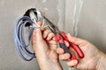 Electricians clears the ends of wires using pliers, hands close-up. Royalty Free Stock Photo