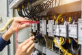 Electricians hands testing current electric in control panel