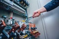 Electricians hands testing switches in electric box. Electrical panel with fuses