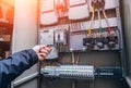 Electricians hands testing switches in electric box. Electrical panel with fuses