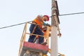 Electricians on the pillars install the mount for the power line. Professional electricians work on the tower Royalty Free Stock Photo