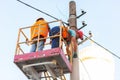 Electricians on the pillars install the mount for the power line. Professional electricians work on the tower Royalty Free Stock Photo