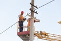 Electricians on the pillars install the mount for the power line. Professional electricians work on the tower Royalty Free Stock Photo