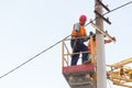 Electricians on the pillars install the mount for the power line. Professional electricians work on the tower Royalty Free Stock Photo