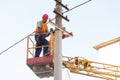 Electricians on the pillars install the mount for the power line. Professional electricians work on the tower Royalty Free Stock Photo