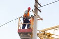 Electricians on the pillars install the mount for the power line. Professional electricians work on the tower Royalty Free Stock Photo