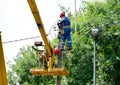 Electricians repair the wires on the pole with the help of a crane lifter.