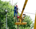 Electricians repair the wires on the pole with the help of a crane lifter.