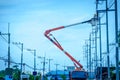 Electricians repairing of electricity on pole with orange crane