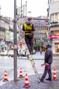 Electricians repairing an energy malfunction on a traffic light pole