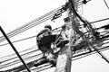 Electricians repairing wire at climbing work on electric post power pole Royalty Free Stock Photo