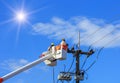 Electricians repairing wire of the power line with bucket hydraulic lifting platform Royalty Free Stock Photo