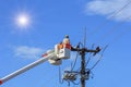 Electricians repairing wire of the power line with bucket hydraulic lifting platform Royalty Free Stock Photo