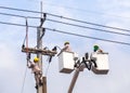 Electricians repairing wire of the power line with bucket hydraulic lifting platform Royalty Free Stock Photo