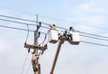 Electricians repairing wire of the power line with bucket hydraulic lifting platform Royalty Free Stock Photo