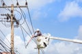 Electricians repairing wire of the power line with bucket hydraulic lifting platform