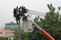 Electricians resting while working to replace the electrical insulator on the electricity pole