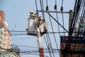 Electricians wiring and repairing wires, workers in buckets, attaching cranes, fixing high-voltage transmission lines.