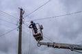 Electricians work on inspection and replacement of lighting poles.