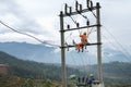 Electricians working high on electricity pole in Vietnam