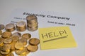 Electricity bill, coins, piggy bank and yellow ticket with `help!` Text. Increase in energy tariffs. Royalty Free Stock Photo