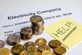 Electricity bill, coins, piggy bank and yellow ticket with `help!` Text. Increase in energy tariffs. Royalty Free Stock Photo