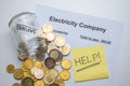 Electricity bill, coins, piggy bank and yellow ticket with `help!` Text. Increase in energy tariffs. Royalty Free Stock Photo