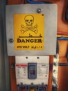 Electricity board switches and danger sign in Arabic and English