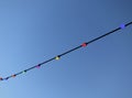 Electricity cable with different colored lamp bulbs against a blue sky Royalty Free Stock Photo