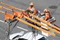 Electricity company employees perform maintenance on distribution line