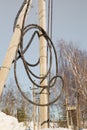 Electricity concept, concrete pole with high voltage cable coiled into a coil.