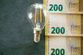 Electricity cost. Light bulb, euro banknotes and coins .Increasing the cost of light and heat.Rising electricity prices