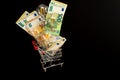 Electricity cost. Light bulbs set and euro banknotes in a supermarket trolley on a black background.Payment of