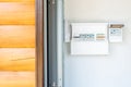 Electricity distribution board with set of automatic circuit breakers and switches near entrance door of wooden garage building. Royalty Free Stock Photo